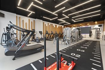 A gym with cardio equipment and weights on the floor